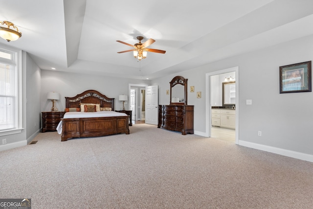 735 Firetower Rd, Thomaston, GA 30286 - bedroom featuring a tray ceiling, light colored carpet, multiple windows, and connected bathroom