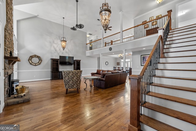 735 Firetower Rd, Thomaston, GA 30286 - living room with a high ceiling, stairway, wood finished floors, a stone fireplace, and a chandelier