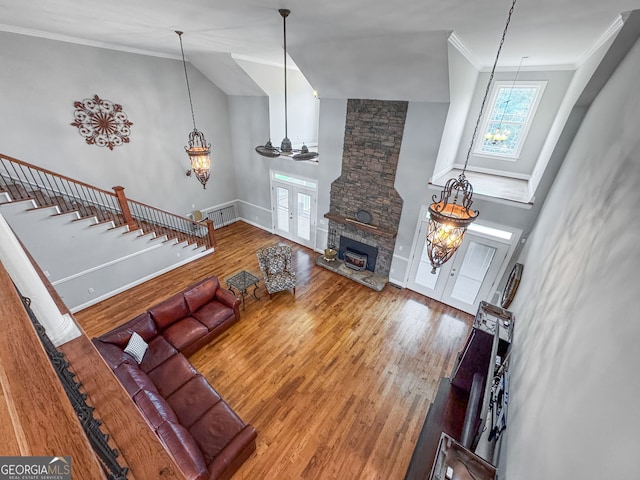 735 Firetower Rd, Thomaston, GA 30286 - living room featuring french doors, wood finished floors, crown molding, a stone fireplace, and lofted ceiling