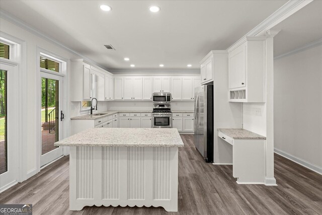 85 Geralds Pt, Wedowee, AL 36278 - kitchen with stainless steel appliances, crown molding, dark wood-type flooring, white cabinetry, and a kitchen island