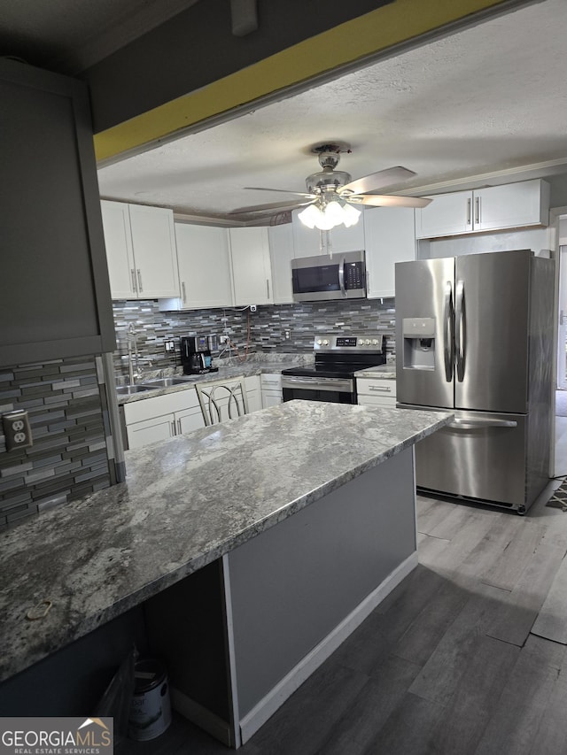 4322 Summerhill Dr, Macon, GA 31204 - kitchen featuring stainless steel appliances, stone counters, white cabinetry, backsplash, and ceiling fan