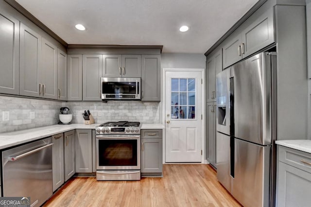 595 Glenforest Rd, Sandy Springs, GA 30328 - kitchen featuring stainless steel appliances, gray cabinets, light wood-style floors, decorative backsplash, and recessed lighting