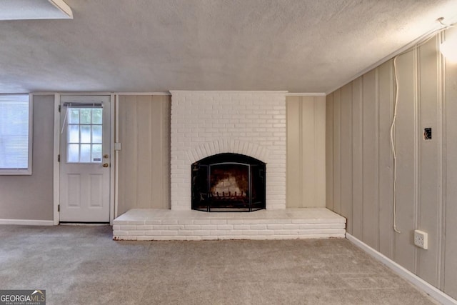 595 Glenforest Rd, Sandy Springs, GA 30328 - unfurnished living room featuring a textured ceiling, a brick fireplace, carpet floors, and a decorative wall