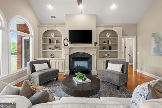 411 Hickory Fairway Ct, Woodstock, GA 30188 - living room featuring lofted ceiling, wood finished floors, a fireplace, and built in features