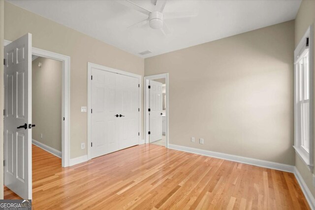 411 Hickory Fairway Ct, Woodstock, GA 30188 - unfurnished bedroom featuring light wood-style flooring, a closet, a ceiling fan, and connected bathroom