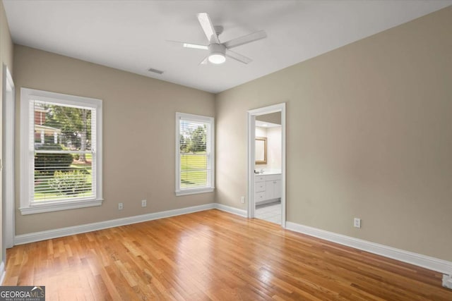 411 Hickory Fairway Ct, Woodstock, GA 30188 - unfurnished bedroom with light wood finished floors, connected bathroom, and a ceiling fan