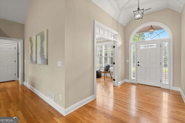 411 Hickory Fairway Ct, Woodstock, GA 30188 - foyer featuring light wood finished floors, a chandelier, and high vaulted ceiling