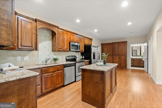411 Hickory Fairway Ct, Woodstock, GA 30188 - kitchen with stainless steel appliances, a center island, light stone countertops, light wood-style floors, and recessed lighting