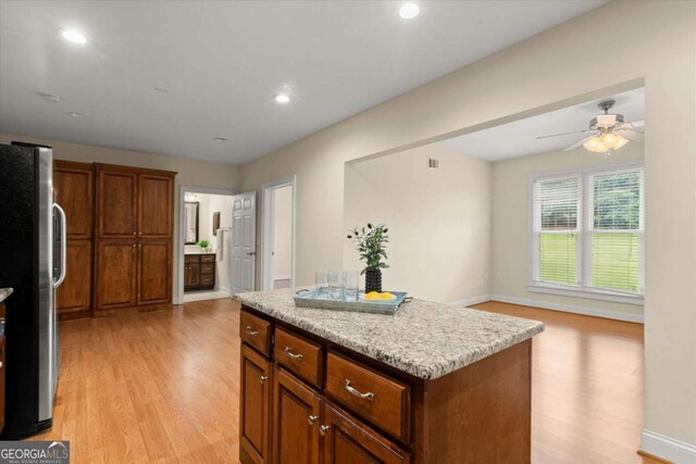 411 Hickory Fairway Ct, Woodstock, GA 30188 - kitchen with freestanding refrigerator, light wood-style flooring, a kitchen island, brown cabinetry, and ceiling fan