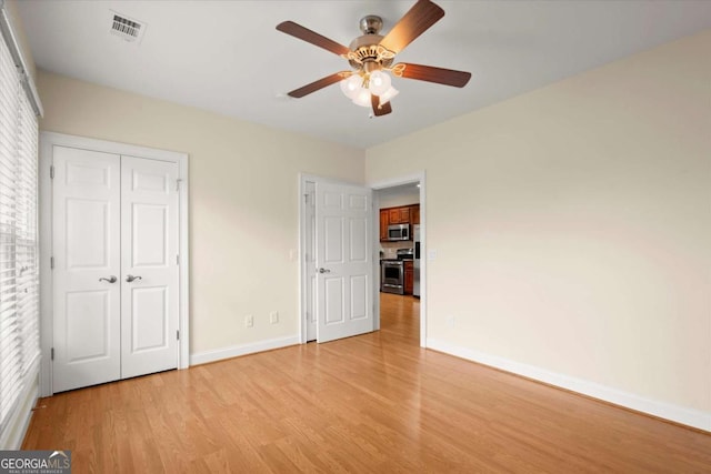 411 Hickory Fairway Ct, Woodstock, GA 30188 - unfurnished bedroom with light wood-style flooring, multiple windows, a closet, and ceiling fan