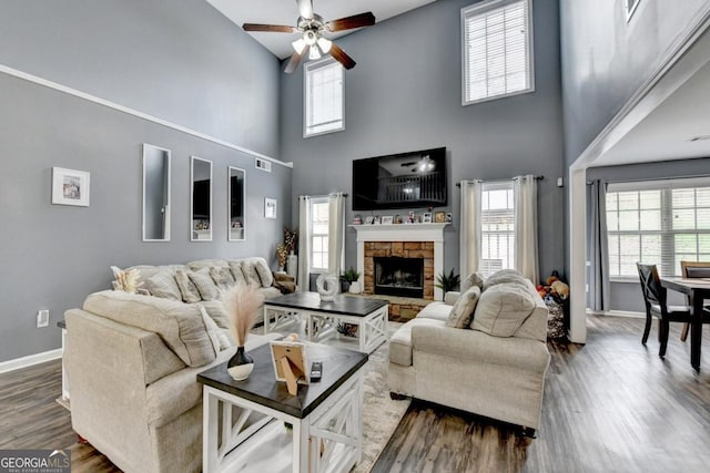 1811 Alberta Ln, Winder, GA 30680 - living room with healthy amount of natural light, a high ceiling, a ceiling fan, dark wood finished floors, and a fireplace