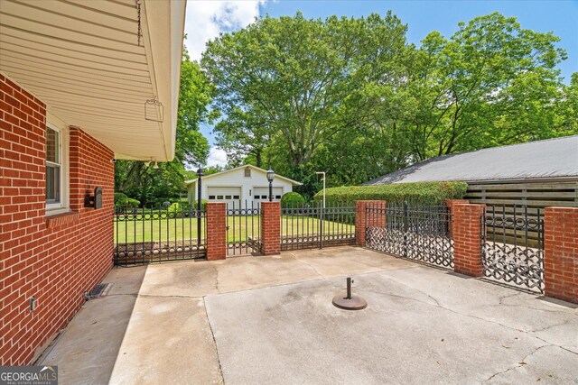 106 Lakeview Dr, Carrollton, GA 30117 - view of patio with an outdoor structure, a detached garage, and a gate