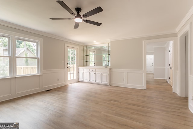 5674 Mountain Cres, Stone Mountain, GA 30087 - empty room with a decorative wall, ornamental molding, a ceiling fan, light wood-type flooring, and wainscoting