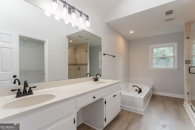 5674 Mountain Cres, Stone Mountain, GA 30087 - bathroom featuring a shower stall, a bath, double vanity, wood finished floors, and a spacious closet