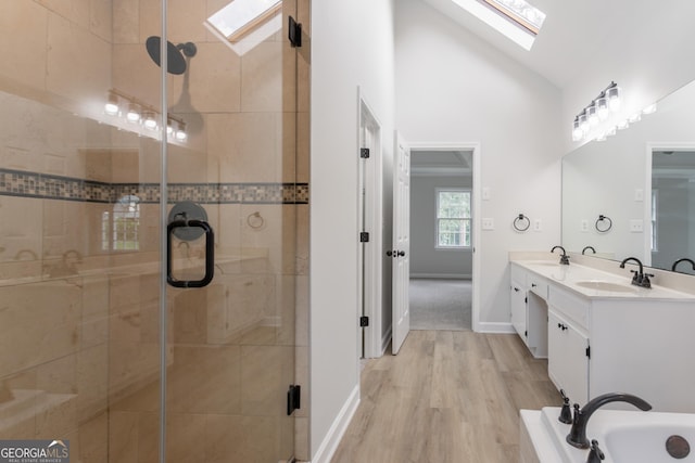 5674 Mountain Cres, Stone Mountain, GA 30087 - bathroom with a skylight, double vanity, a shower stall, wood finished floors, and high vaulted ceiling