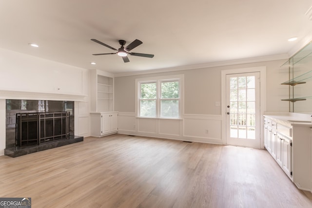 5674 Mountain Cres, Stone Mountain, GA 30087 - unfurnished living room featuring healthy amount of natural light, a ceiling fan, a high end fireplace, crown molding, and light wood finished floors