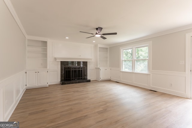 5674 Mountain Cres, Stone Mountain, GA 30087 - unfurnished living room with built in features, ceiling fan, a decorative wall, crown molding, and a high end fireplace