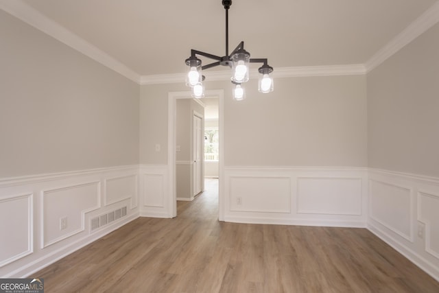 5674 Mountain Cres, Stone Mountain, GA 30087 - unfurnished dining area featuring crown molding, wainscoting, wood finished floors, and a decorative wall