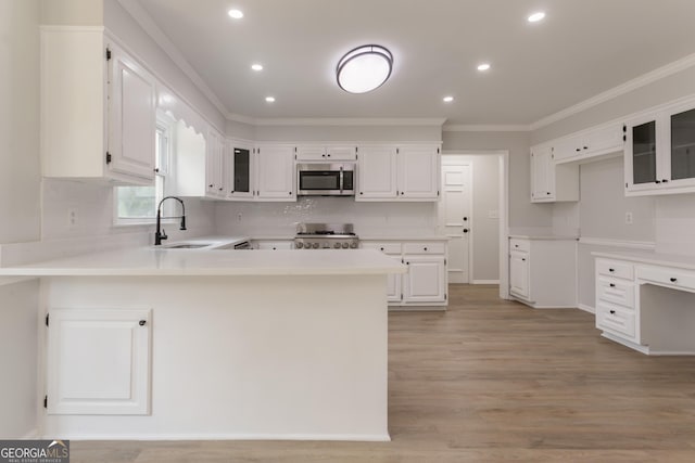 5674 Mountain Cres, Stone Mountain, GA 30087 - kitchen featuring stainless steel microwave, range, ornamental molding, a peninsula, and backsplash