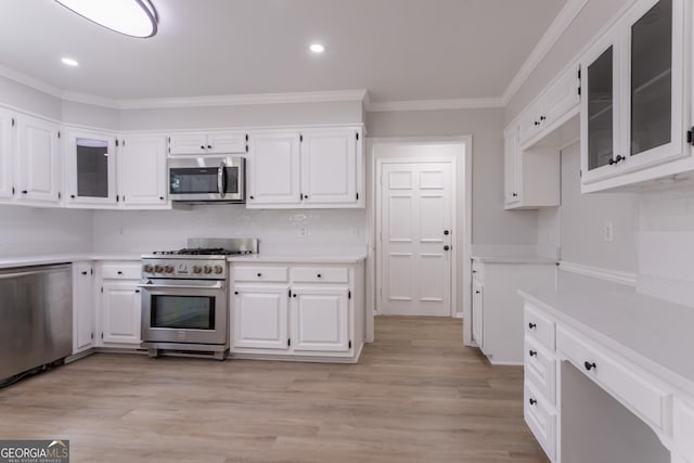 5674 Mountain Cres, Stone Mountain, GA 30087 - kitchen with appliances with stainless steel finishes, light countertops, crown molding, white cabinets, and glass insert cabinets
