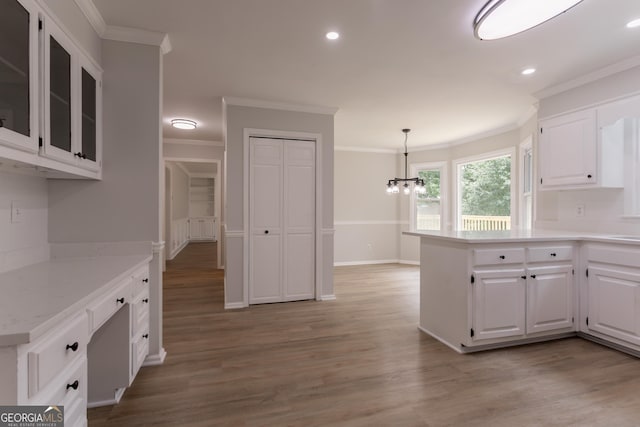 5674 Mountain Cres, Stone Mountain, GA 30087 - kitchen featuring crown molding, a chandelier, white cabinetry, light wood finished floors, and glass insert cabinets
