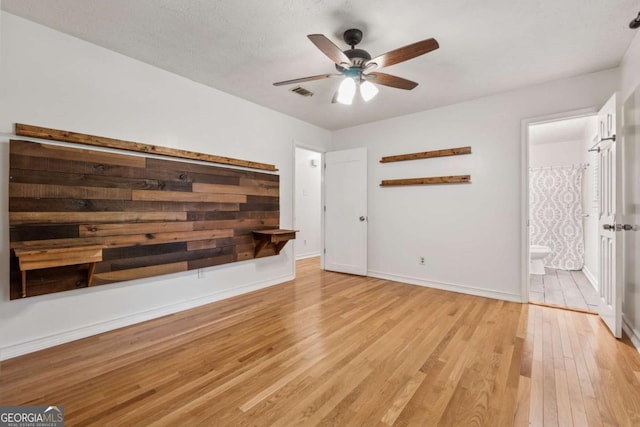 3123 Deshong Dr, Stone Mountain, GA 30087 - unfurnished bedroom with light wood finished floors, connected bathroom, and a ceiling fan