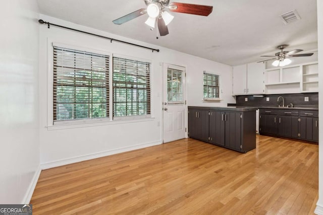 3123 Deshong Dr, Stone Mountain, GA 30087 - kitchen featuring a ceiling fan, open shelves, light wood finished floors, tasteful backsplash, and white cabinets