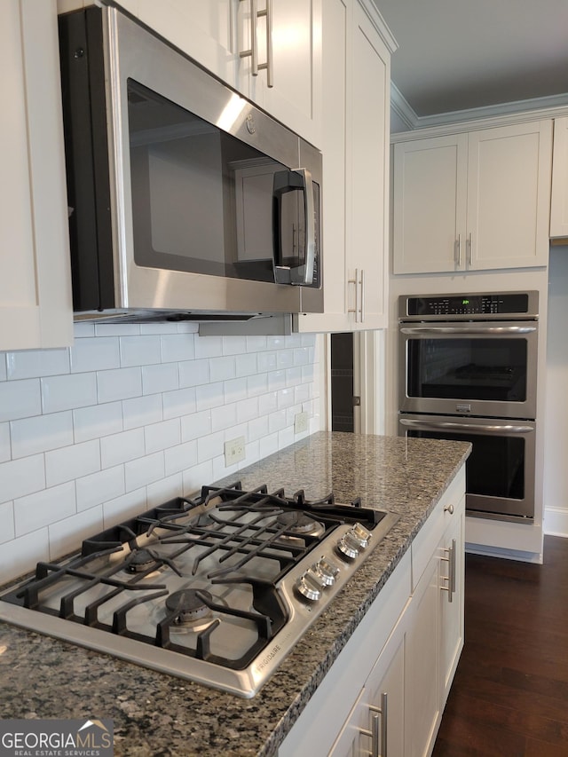 2424 Saint Andrews Rdg, College Park, GA 30337 - kitchen featuring stainless steel appliances, white cabinets, dark stone countertops, dark wood-style flooring, and tasteful backsplash
