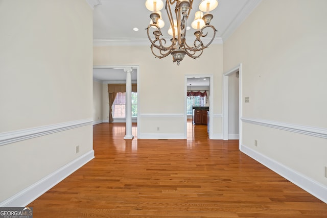 152 Lace Field Ln, Lavonia, GA 30553 - unfurnished dining area featuring ornate columns, crown molding, light wood-type flooring, and a chandelier