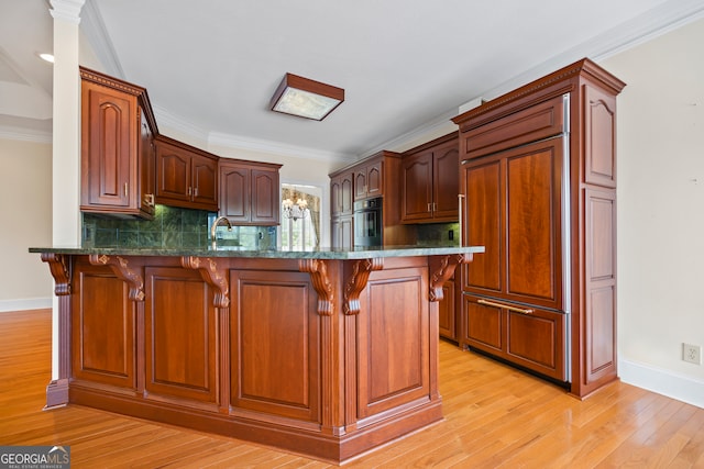 152 Lace Field Ln, Lavonia, GA 30553 - kitchen featuring a peninsula, a breakfast bar, paneled built in refrigerator, black oven, and light wood-style flooring