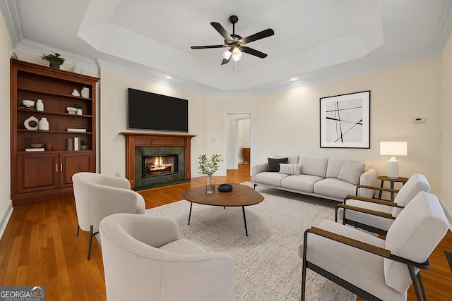 152 Lace Field Ln, Lavonia, GA 30553 - living room featuring a tray ceiling, wood finished floors, a premium fireplace, a ceiling fan, and ornamental molding