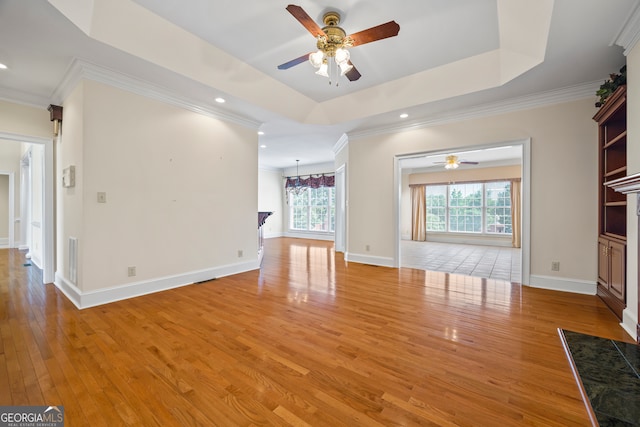 152 Lace Field Ln, Lavonia, GA 30553 - unfurnished living room featuring ceiling fan, light wood-style flooring, recessed lighting, crown molding, and a tray ceiling