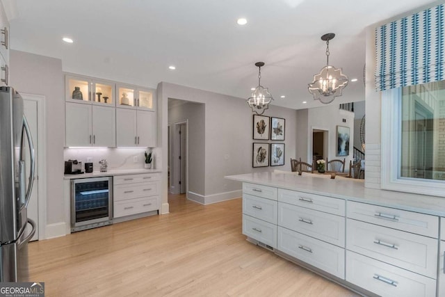 5414 Manteo Inlt, Peachtree Corners, GA 30092 - kitchen featuring beverage cooler, freestanding refrigerator, a chandelier, white cabinetry, and light countertops