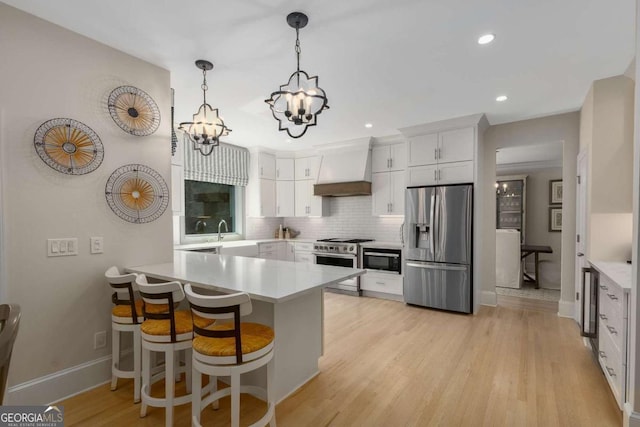 5414 Manteo Inlt, Peachtree Corners, GA 30092 - kitchen featuring stainless steel appliances, premium range hood, a peninsula, a chandelier, and light countertops
