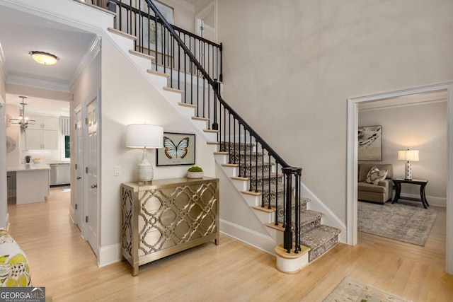 5414 Manteo Inlt, Peachtree Corners, GA 30092 - stairs with wood finished floors, ornamental molding, a chandelier, and a high ceiling