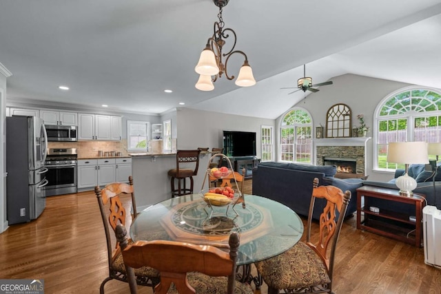 2864 Wyndcliff Ct, Marietta, GA 30066 - dining room featuring ceiling fan, healthy amount of natural light, a stone fireplace, lofted ceiling, and recessed lighting