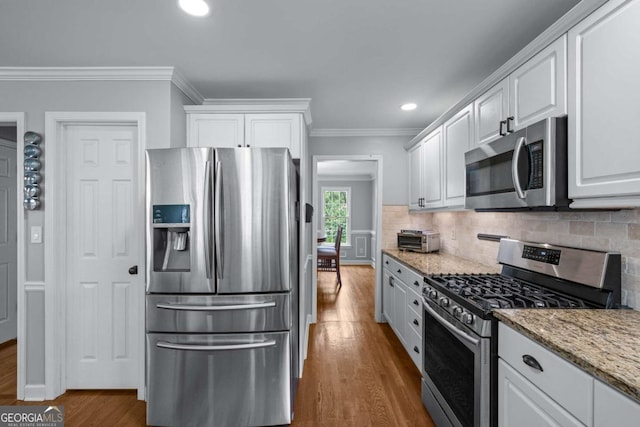 2864 Wyndcliff Ct, Marietta, GA 30066 - kitchen with stainless steel appliances, crown molding, white cabinets, wood finished floors, and backsplash
