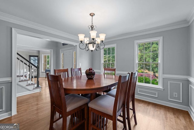 2864 Wyndcliff Ct, Marietta, GA 30066 - dining area with a chandelier, wood finished floors, stairway, a wainscoted wall, and crown molding