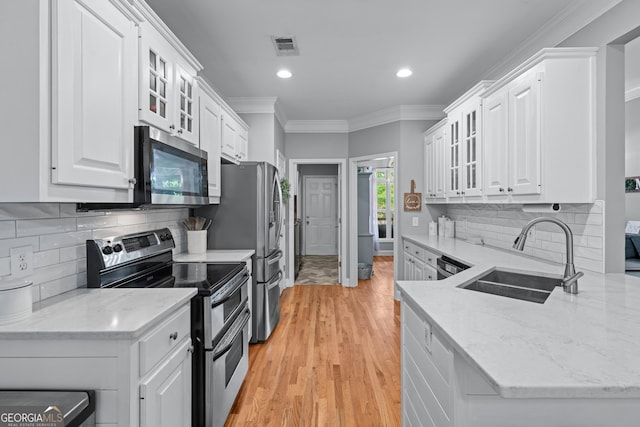 1436 Virginia Way, Monroe, GA 30655 - kitchen with stainless steel appliances, white cabinetry, light wood finished floors, crown molding, and recessed lighting