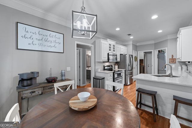 1436 Virginia Way, Monroe, GA 30655 - dining area featuring ornamental molding, light wood finished floors, recessed lighting, and a chandelier