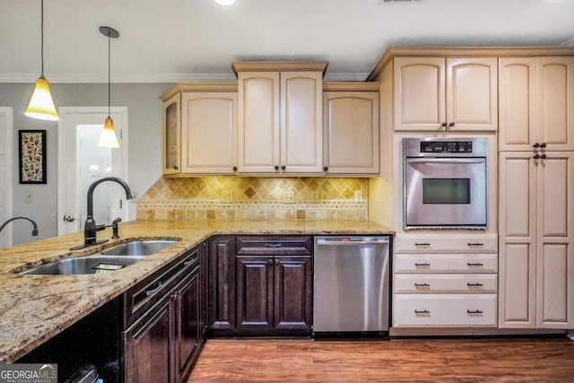 186 Ashley Dr, Mcdonough, GA 30252 - kitchen with stainless steel appliances, light stone counters, hanging light fixtures, crown molding, and wood finished floors