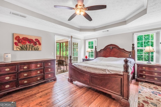 186 Ashley Dr, Mcdonough, GA 30252 - bedroom with a raised ceiling, hardwood / wood-style floors, multiple windows, ornamental molding, and a textured ceiling