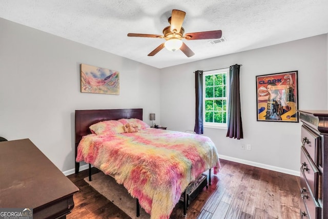 186 Ashley Dr, Mcdonough, GA 30252 - bedroom with dark wood-style flooring, a textured ceiling, and ceiling fan
