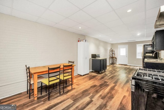 186 Ashley Dr, Mcdonough, GA 30252 - dining room featuring a paneled ceiling, dark wood finished floors, and brick wall