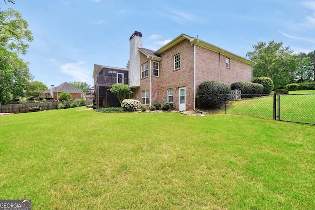 186 Ashley Dr, Mcdonough, GA 30252 - rear view of property featuring a chimney, stairway, brick siding, and a deck