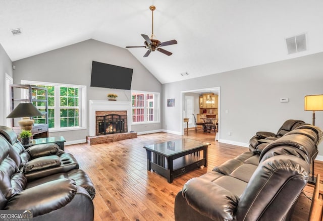 186 Ashley Dr, Mcdonough, GA 30252 - living area with high vaulted ceiling, a ceiling fan, light wood-style floors, a chandelier, and healthy amount of natural light