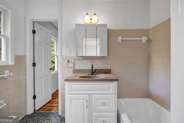 2585 Regency Dr E, Tucker, GA 30084 - full bath featuring tile walls, a bath, vanity, and wainscoting