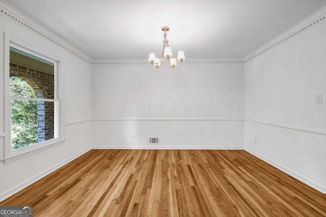 2585 Regency Dr E, Tucker, GA 30084 - empty room featuring a chandelier, light wood-style floors, and ornamental molding