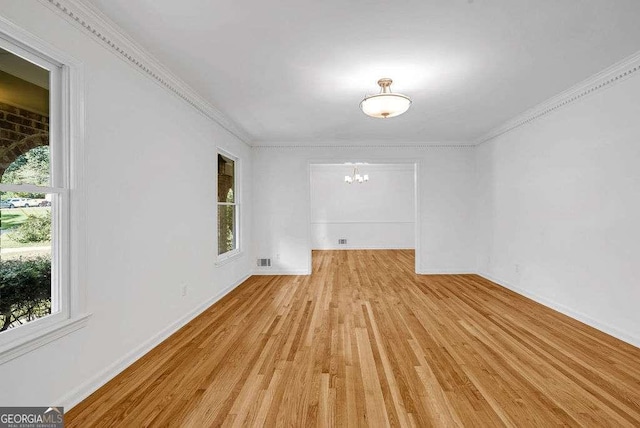 2585 Regency Dr E, Tucker, GA 30084 - unfurnished room with a chandelier, light wood-style floors, healthy amount of natural light, and ornamental molding