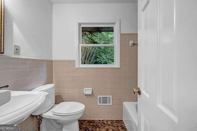 2585 Regency Dr E, Tucker, GA 30084 - full bath featuring tile walls, a wainscoted wall, and tile patterned flooring